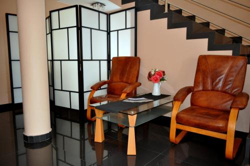 波德拉谢地区拉曾Hotel Pauza的两把椅子和一张带花瓶的桌子