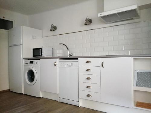 特鲁埃尔Apartamento Torreón de la Bombardera的白色的厨房配有洗衣机和洗衣机