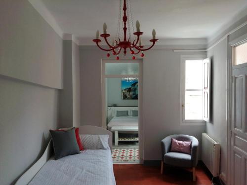 特鲁埃尔Apartamento Torreón de la Bombardera的一间卧室配有一张床、一把椅子和一个吊灯。