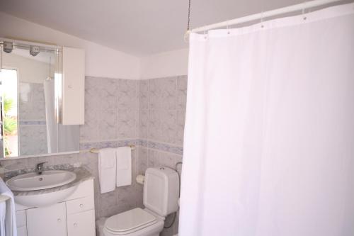 塞勒玛Salema Beach Private Villa的浴室设有卫生间、水槽和淋浴帘