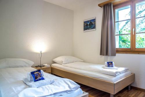 格林德尔瓦尔德Apartment Dolomit EG - GRIWA RENT AG的带窗户的客房内的两张床
