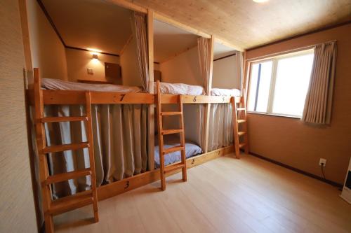 根室市Guest House Nemuroman的客房设有两张双层床和一扇窗户。