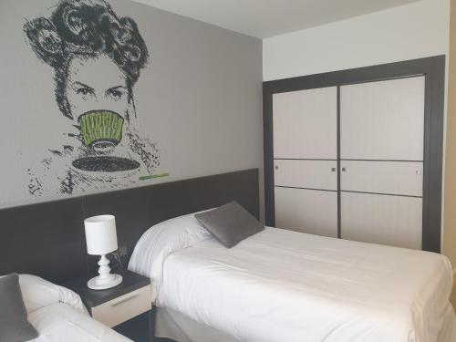 维多利亚-加斯特伊兹Hotel Arts - Gasteiz Centro的一间卧室设有两张床,墙上挂着一幅画