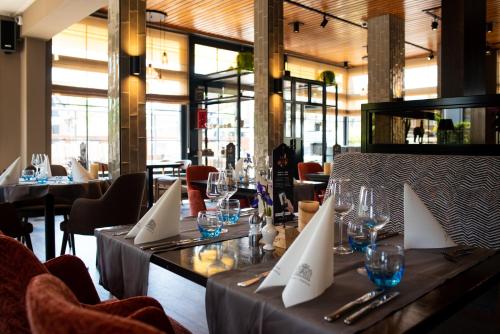 罗登德伦特的武器酒店的餐厅配有带玻璃杯和餐巾的桌子