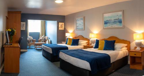 塔伯柯里墨菲斯酒店的酒店客房带两张带蓝色和黄色枕头的床
