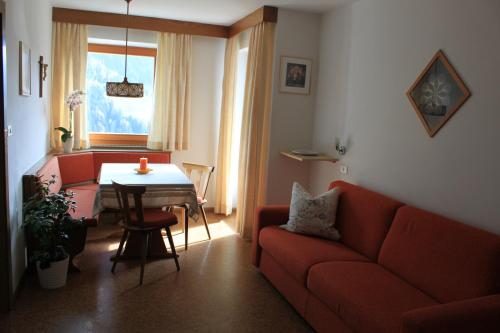 圣洛伦佐-迪塞巴托Haus Tasser的客厅配有红色的沙发和桌子