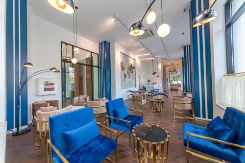 库塔伊西Newport Hotel Kutaisi的一间设有蓝色椅子和桌子的等候室