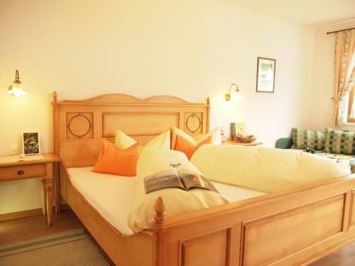 萨姆瑙恩Apart-Garni Motnaida的一间卧室配有一张带枕头的大型木制床。