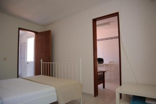塞勒玛Salema Beach Private Villa的一间卧室配有一张床、一把椅子和镜子