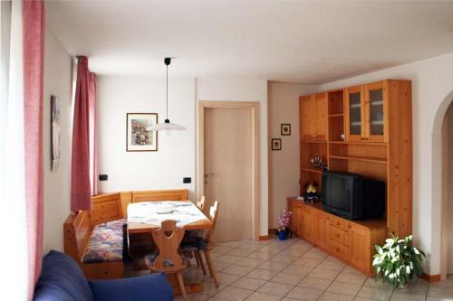 泰塞罗Appartamenti Piazzi的一间带桌子的客厅和一间餐厅