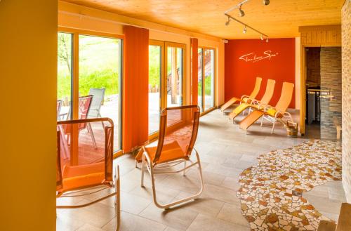 塔姆斯韦格Tonibauer的客厅配有橙色墙壁和椅子