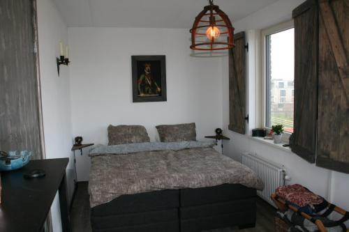 阿尔梅勒B&B Het kasteel的一间卧室设有一张床和一个窗口