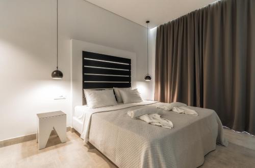基普塞利Belussi Exclusive Suites的白色卧室配有一张带白色毯子的床