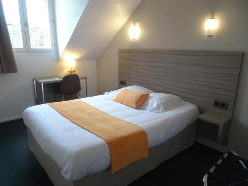 圣布里厄Hôtel Ker Izel Saint-Brieuc Centre Historique的一间卧室配有一张大床和木制床头板