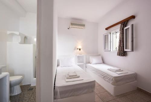 基斯诺斯Kanala Studios的白色的客房设有两张床和卫生间