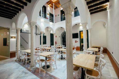 塞维利亚Hotel Cetina Sevilla的大楼内带桌椅的用餐室