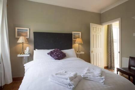 克利夫登Errismore House的卧室配有白色床和毛巾