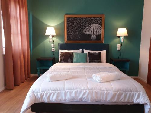 塞尔马Aigaion Guesthouse的一间卧室配有一张带两盏灯的大型白色床。