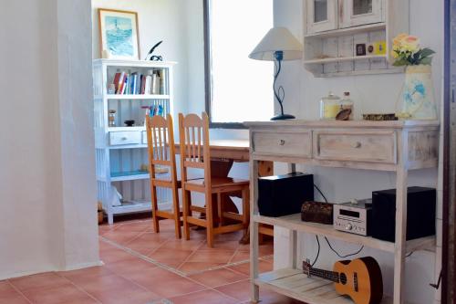 福尔内利斯Apartamento en el mar con terraza的客房设有书桌和带吉他桌的桌子。