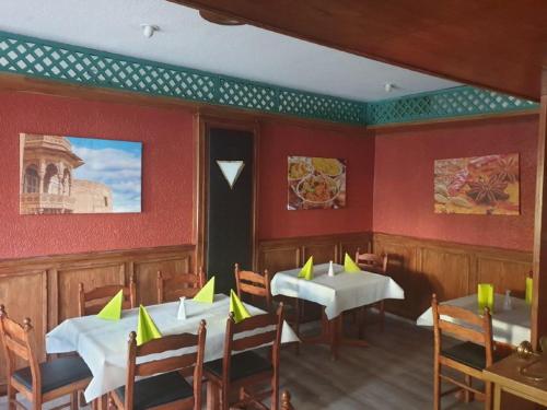 宾茨格兰之酒店的餐厅设有两张桌子和椅子,配黄色餐巾