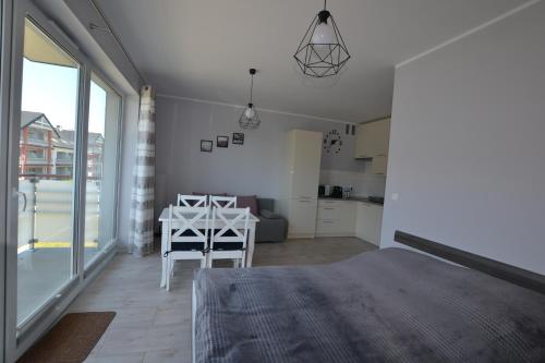 达洛科Darłówko Apartament Morski V的一间卧室配有一张床铺和一张桌子,还设有一间厨房