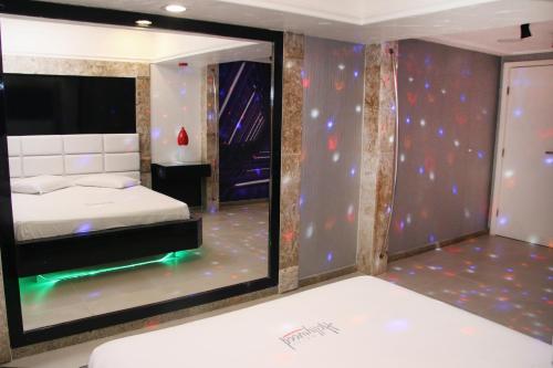 萨尔瓦多Motel Hollywood的一间卧室配有一张床和一面大镜子
