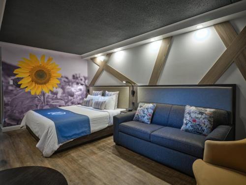 里维耶尔·杜·卢普卢普河会议中心环球大酒店的一间卧室配有一张床和一张沙发