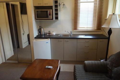 亨特利NZ庄园美景酒店的一个带水槽和桌子的小厨房