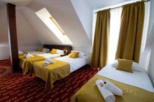 姆德尼擦Dworek Magnat的酒店客房设有三张床和窗户。