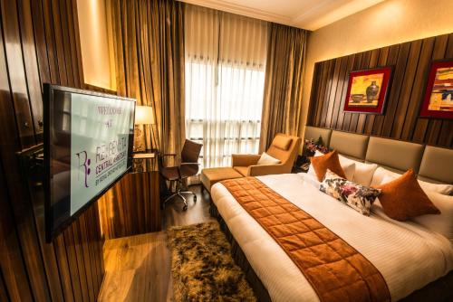 阿姆利则Regenta Central Amritsar的配有一张床和一台平面电视的酒店客房