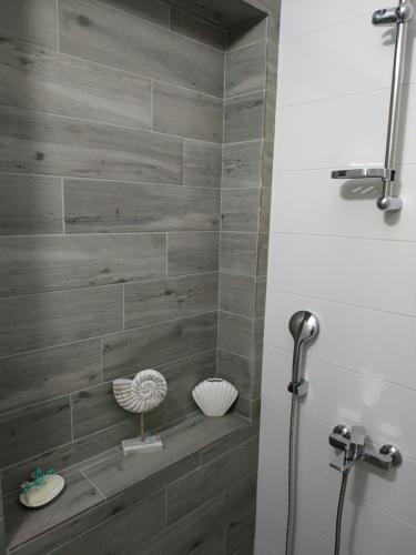 卡拉马塔Arxontia 2的浴室设有灰色瓷砖淋浴。