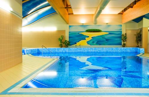 卡罗维发利中央国际酒店的游泳池位于酒店房间,墙上挂着一幅画