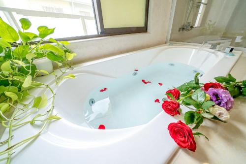 台南拍R平方电梯民宿的浴室配有带鲜花的浴缸。