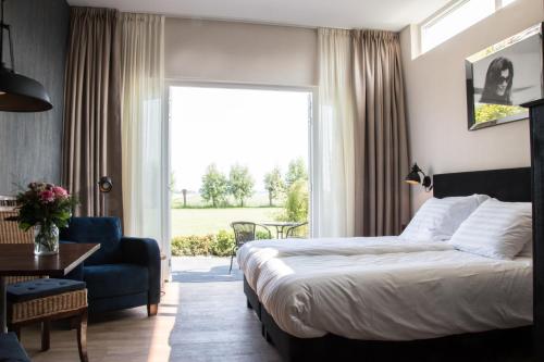 OosterblokkerDe tien Wilgen的酒店的客房 - 带一张床、椅子和窗户