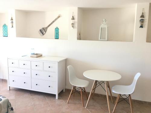蓬塔迪亚B&B Tavolara的卧室配有白色的桌椅和梳妆台