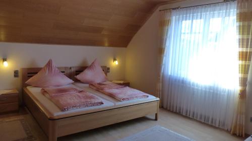 策尔廷根-拉蒂希Ferien Apartment Melcher的一间卧室配有带粉红色枕头的床和窗户。