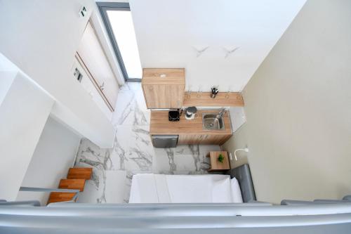斯塔夫罗斯Alos Utopia的小型阁楼间设有白色家具和楼梯。