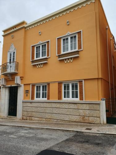 法鲁Inn Faro - Casa Amarela - Guest House的黄色的建筑,有窗户和门