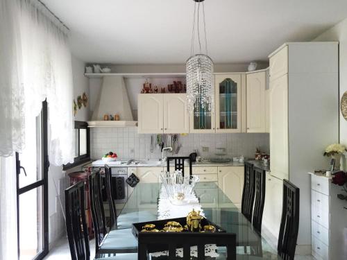 塞拉瓦莱皮斯托耶塞CASA Lux的厨房配有玻璃桌和白色橱柜