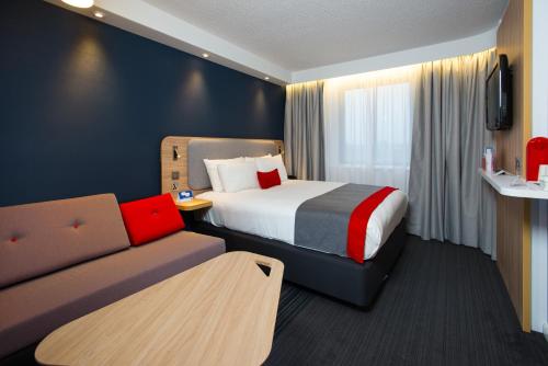 卢顿快捷假日伦敦卢顿机场酒店的酒店客房,配有床和沙发