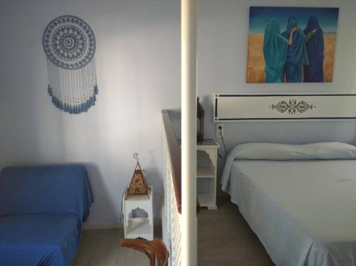 桑卢卡尔-德巴拉梅达El apartaito的一间卧室配有两张床、一张桌子和一张图片