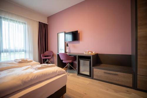 贾尔A22 Hotel Gyál的配有一张床和一张书桌的酒店客房