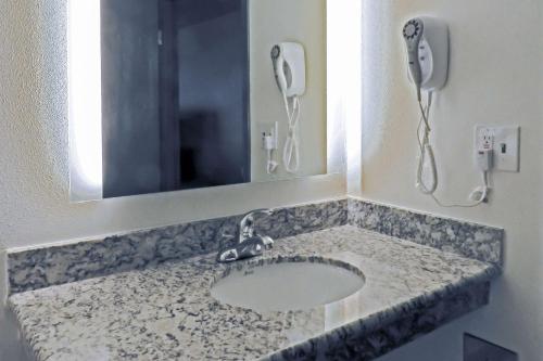 埃弗里特Quality Inn & Suites Everett的一间带镜子和电话的盥洗盆的浴室