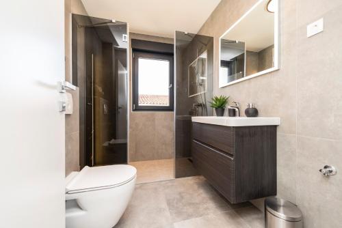 比比涅Villa Fresca的一间带卫生间、水槽和镜子的浴室