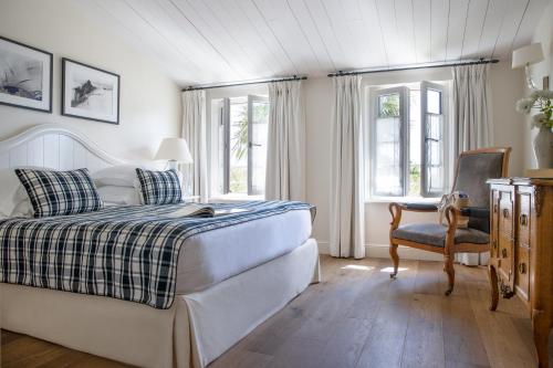 圣马丹德雷Villa Clarisse & Spa by Olivier Claire的一间卧室配有一张床、一把椅子和窗户。