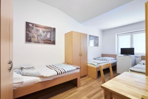 布拉格Apartmány Ubytování Alfa的客房设有两张双层床和一张桌子。