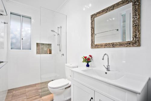 科夫斯港Jetty Splendour Guest Bedroom with Bathroom en-suite B'nB的一间带卫生间、水槽和镜子的浴室