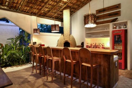 普拉亚埃斯佩洛Hotel Calá & Divino的酒吧,餐厅里摆放着一排椅子