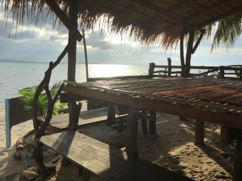 纳通市The Dreamcatcher or Samui sunset Hostel的海边的桌子和长椅