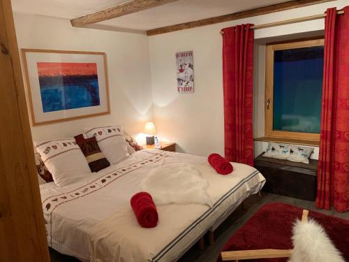 圣福瓦-塔朗泰斯Chalet JJ的一间卧室配有一张带红色枕头的床